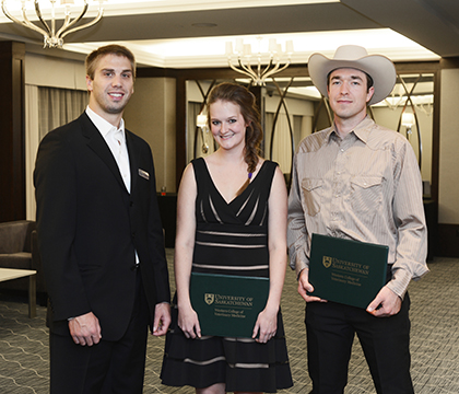 Dr. Eric Lawrence (left), a member of the WCVM Class of 2013, presents the inaugural Vetavision Award to students Kayla Bilsborrw (centre) and Colton McAleer. Photo by Debra Marshall.