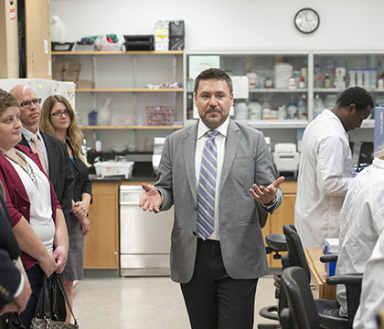 Researcher Dr. Curtis Ponzniak leads a lab tour following a Genome Canada funding announcement on July 21. The Canadian Press Images/Liam Richards.