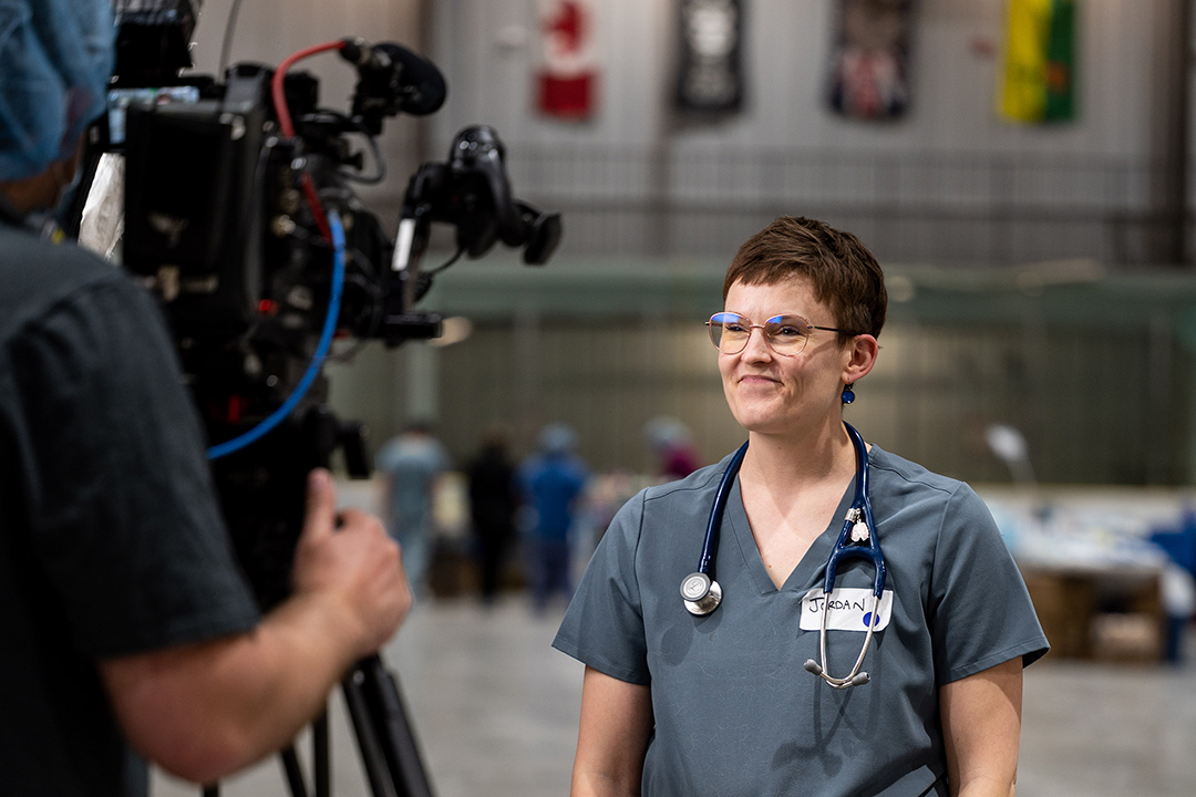Dr. Jordan Woodsworth, being interviewed by a film crew during a veterinary clinic held in La Ronge, Sask. Photo by Brandon White (b/w photo). 