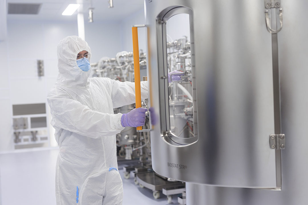 An employee in protective gear works inside the VIDO's vaccine manufacturing facility 