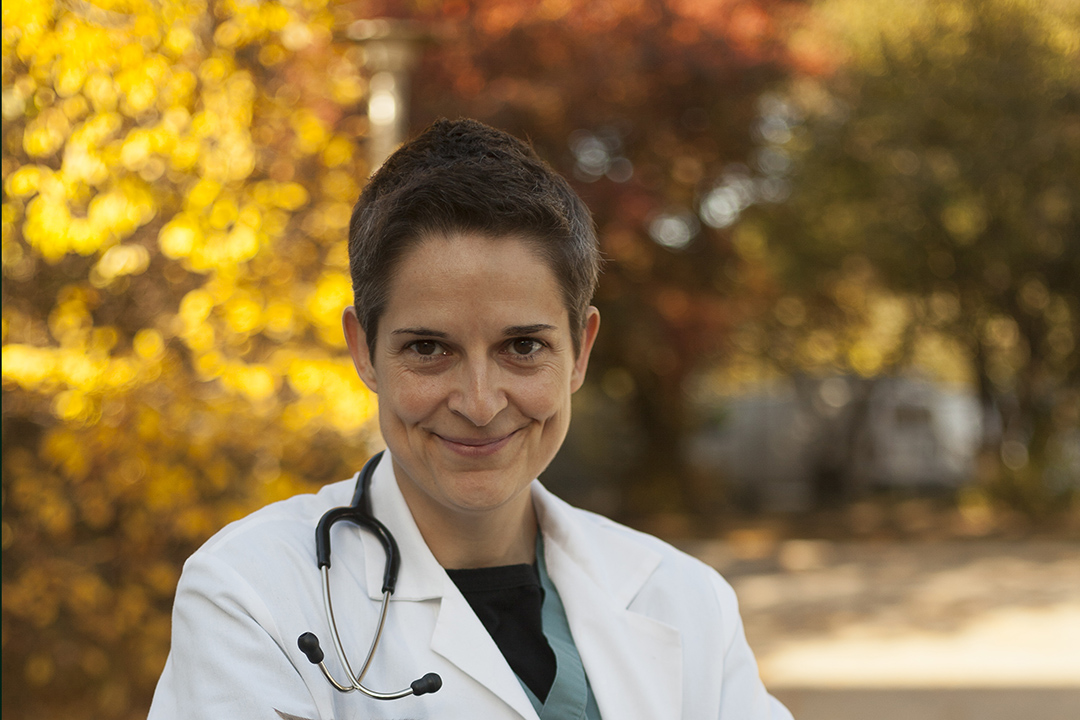 Veterinarian in front of bright leaves