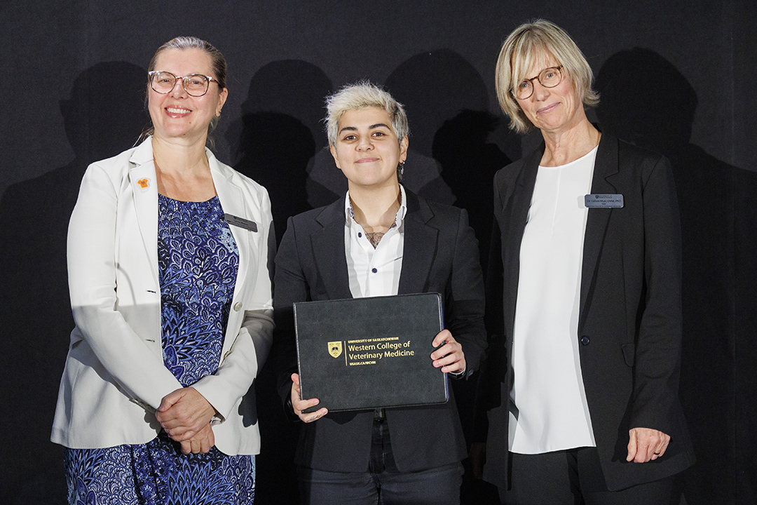 Yas Ranjbar accepts the DIVERSE award from Drs. Weber and Muir at awards ceremony