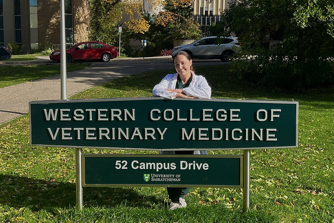 Vet student Arisia Swystun stands beside the WCVM sign outside of the veterinary college.