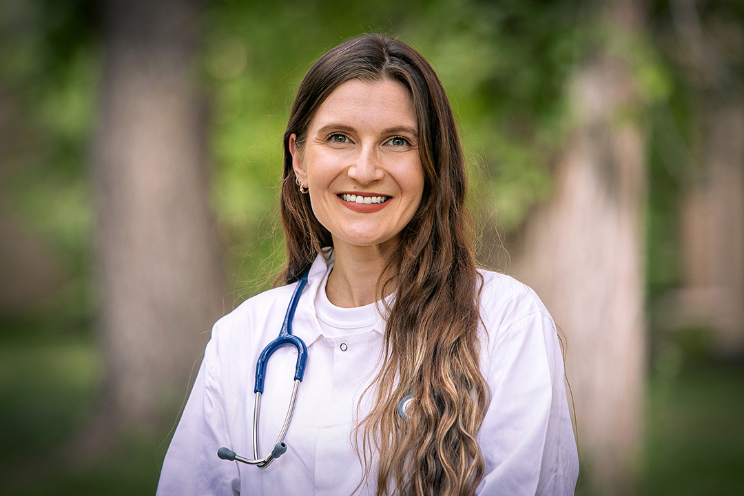 Jen Svilik, a first-year veterinary student at the WCVM, in her white coat and stethoscope.