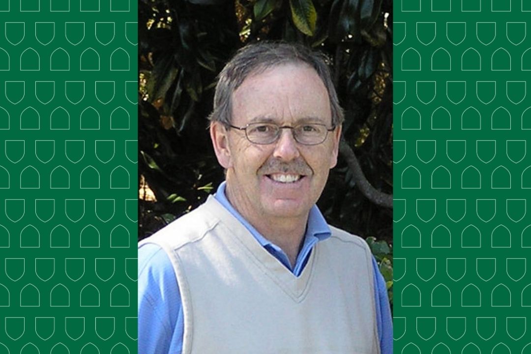 A headshot of Kenneth Mould, surrounded by a green background with small white crests.