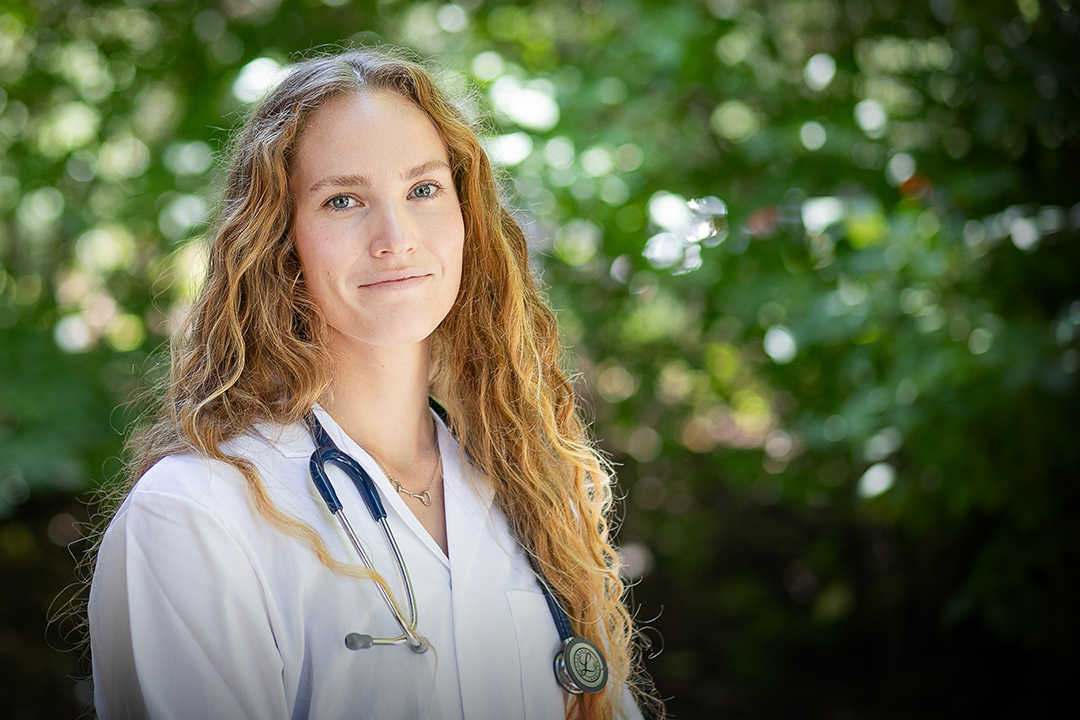 Kyra Westman, veterinary student, in white coat and stethoscope