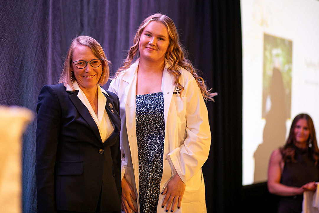 Dr. Tracy Fisher (left) welcomes Sydney Hogg, a first-year WCVM student, at the college's annual white coat ceremony in October 2025. Photo: Christina Weese. 